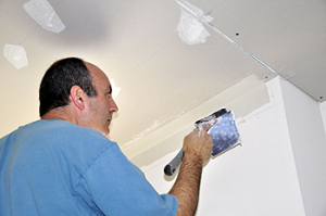 a Union City handyman service pro applies a layer of mud to a ceiling joint 